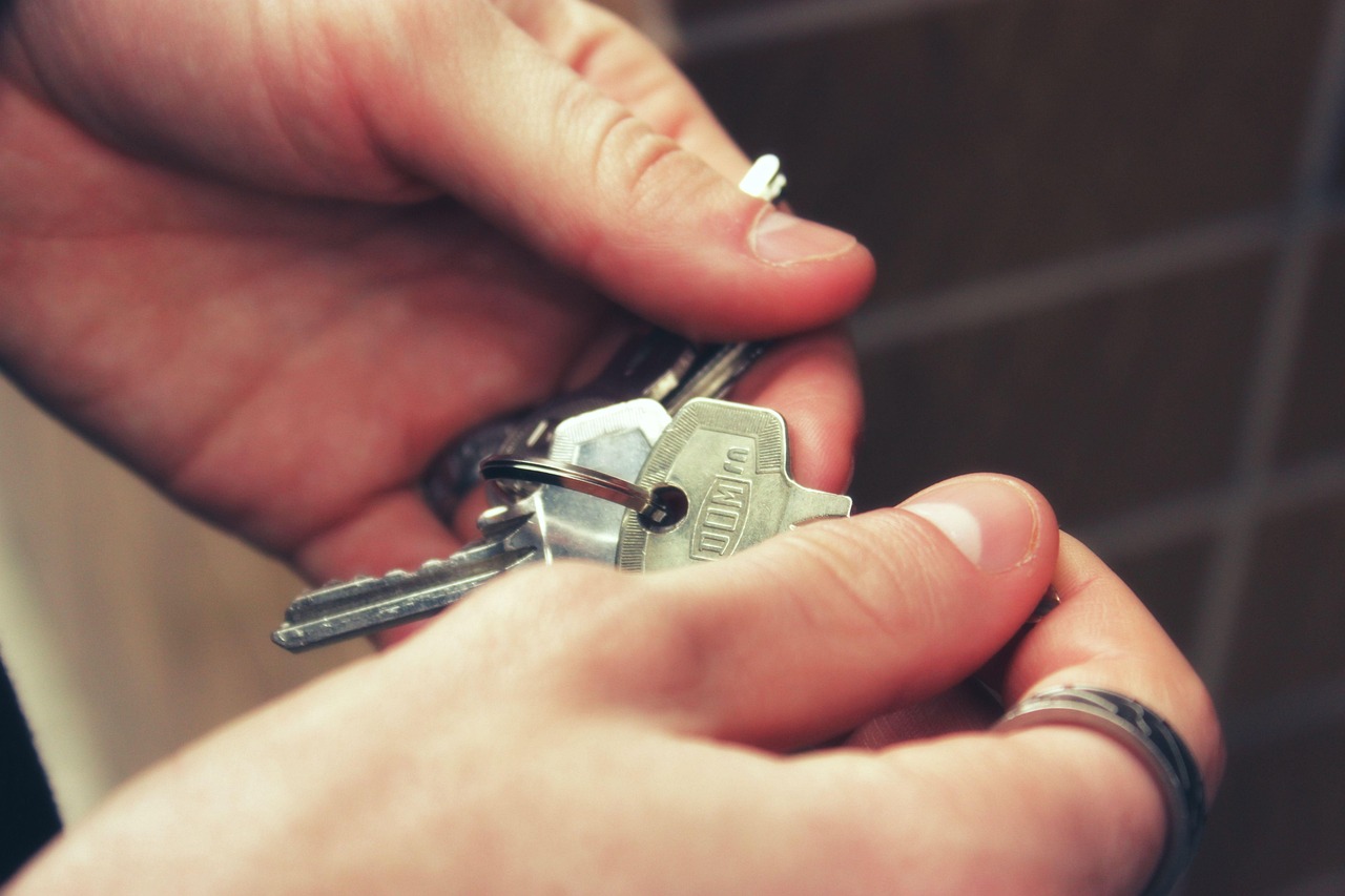 Deux mains échangeant un trousseau de clés de maison