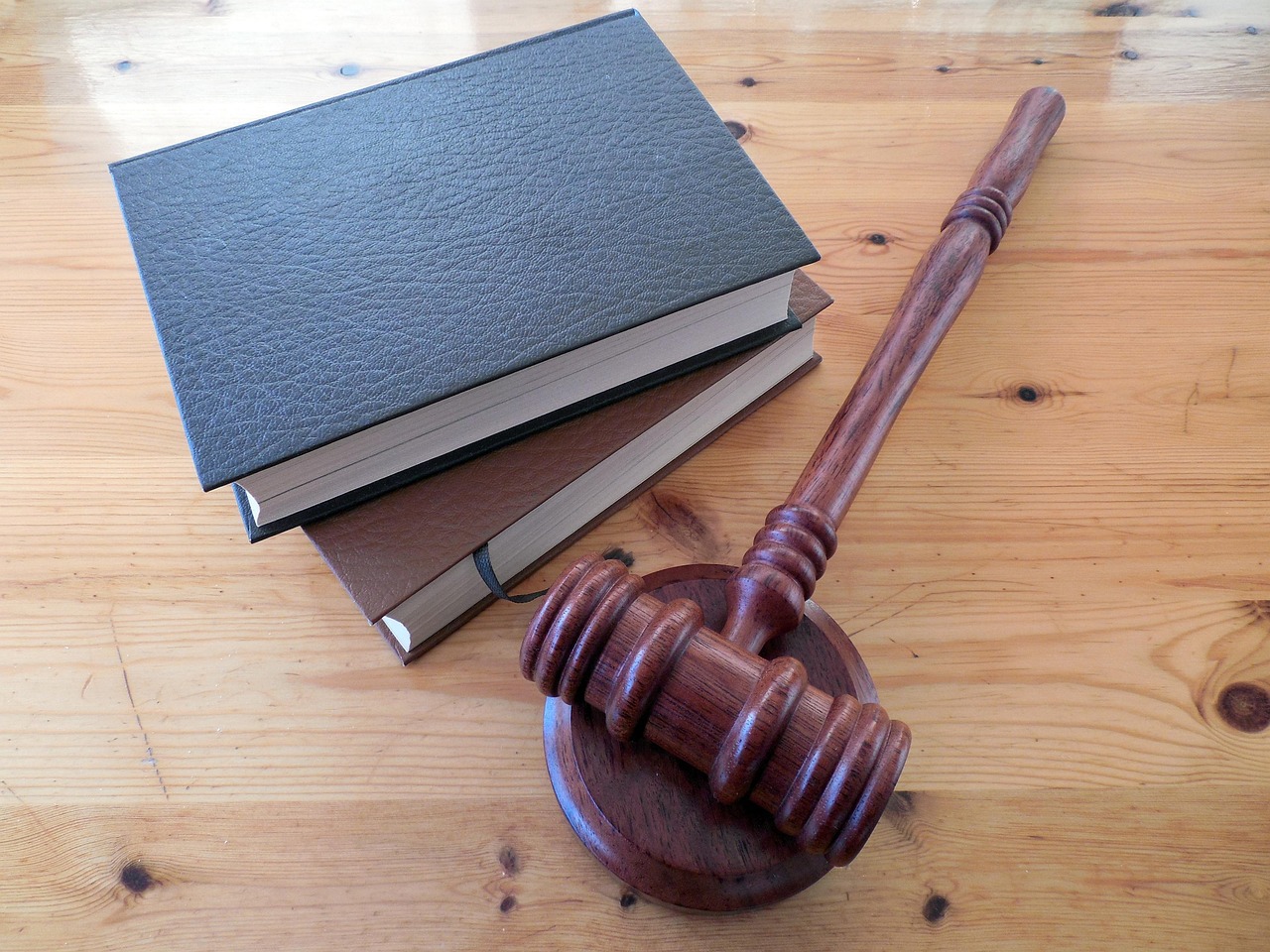 Marteau de juge posé sur des livres de droit sur un bureau en bois