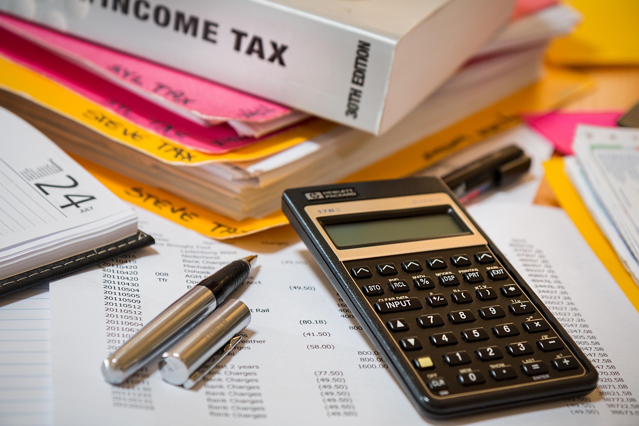 Calculatrice posée sur des documents avec un dossier income tax
