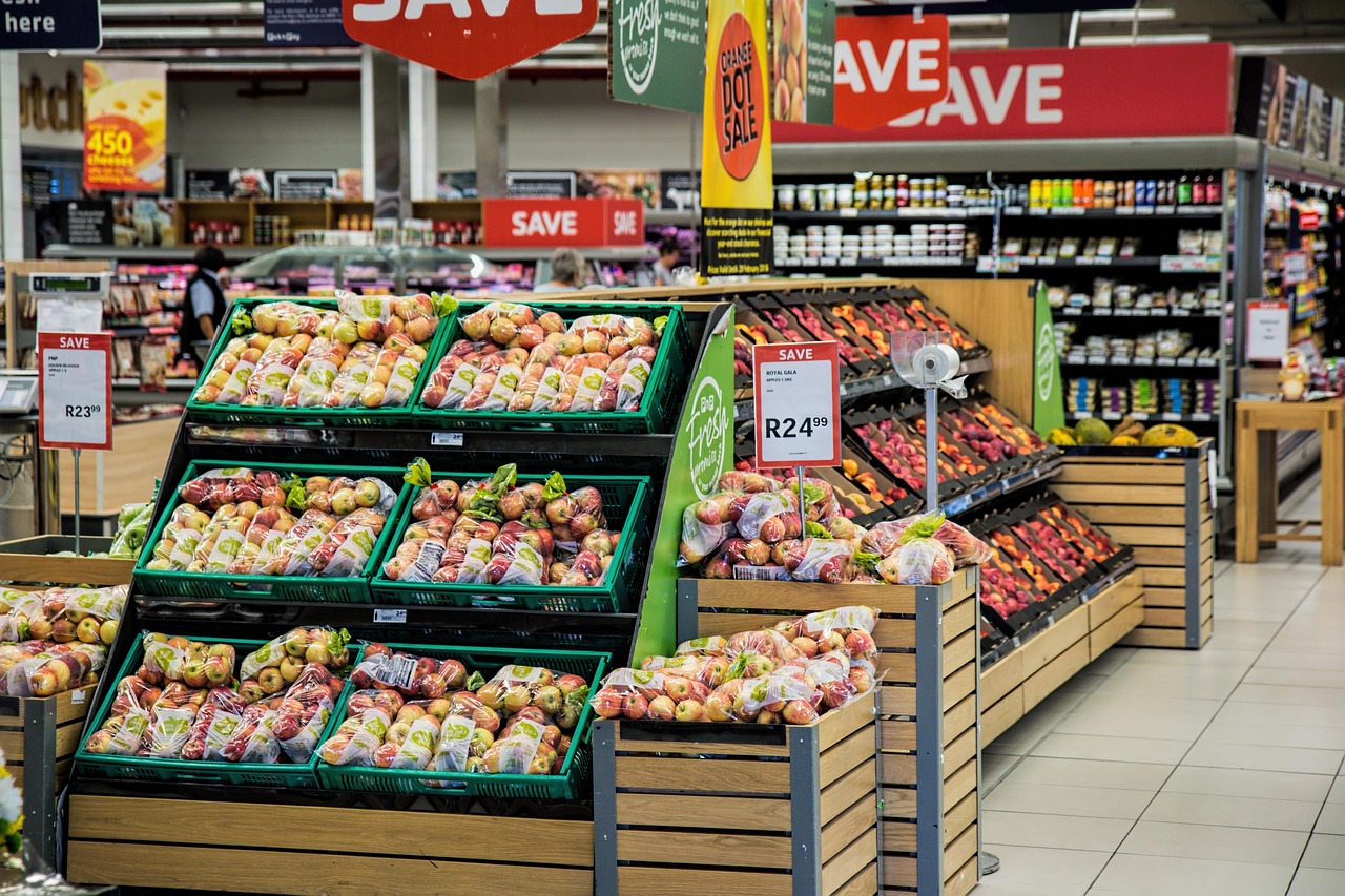 Étal de fruits et légumes dans un supermarché avec panneaux de prix promotionnels